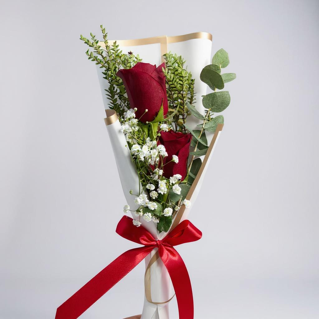 2 rosas rojas en ramo con eucalipto