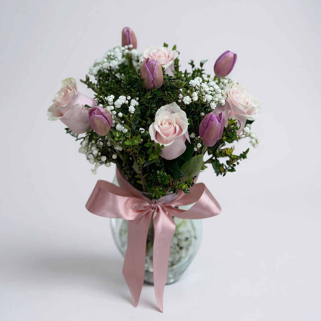 Florero de tulipanes y rosas en tonos rosados